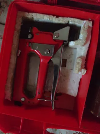 Grapadora manual roja con maletín