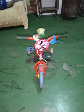 Bicicleta infantil roja con ruedines