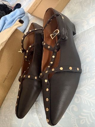 Zapatos negros con tachuelas doradas