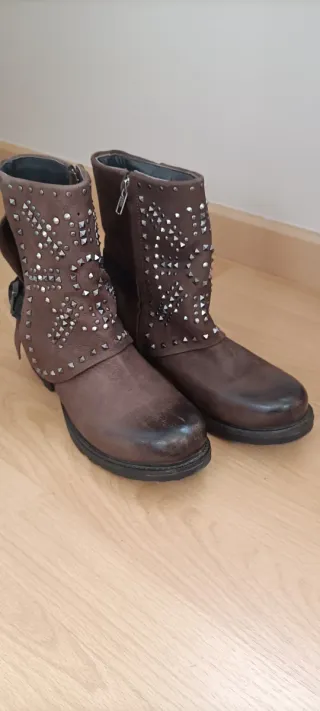 Botas de piel marrones con tachuelas plateadas.