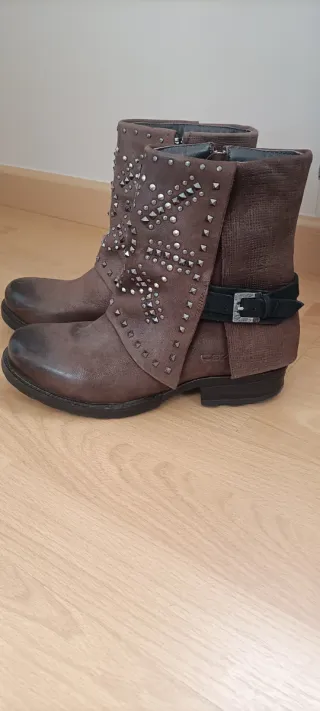 Botas de piel marrones con tachuelas plateadas.