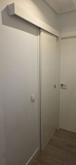 Puerta corredera blanca de madera