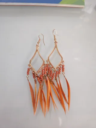 Pendientes dorados con plumas naranjas