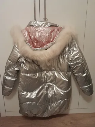 Abrigo plateado metálico espacial con capucha.