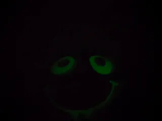 Cojín infantil azul con cara sonriente.