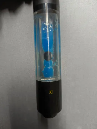 Taco de billar con líquido y bolitas