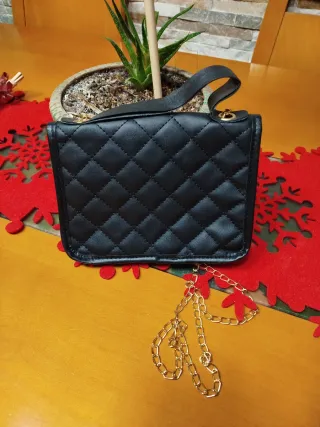Bolso negro con cadena dorada.