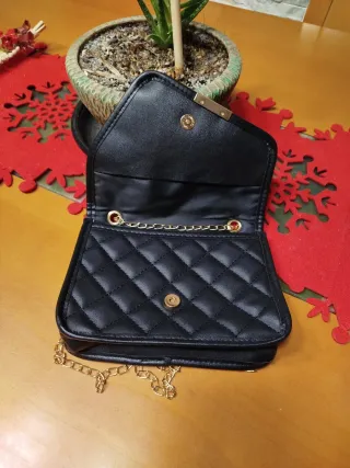 Bolso negro con cadena dorada.