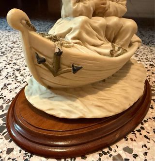 Escultura titulada: Love in a bot. Es antigua.