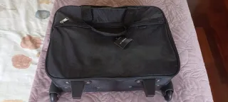 Maleta de viaje negra con ruedas.