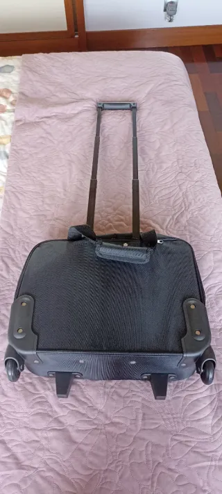 Maleta de viaje negra con ruedas.