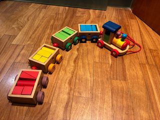 Tren de madera con vagones de construcción. Goki