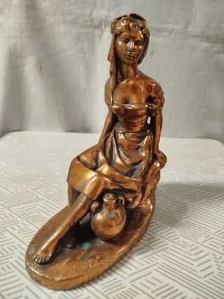 Escultura de mujer sentada con cántaro, en bronce.