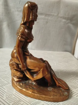 Escultura de mujer sentada con cántaro, en bronce.