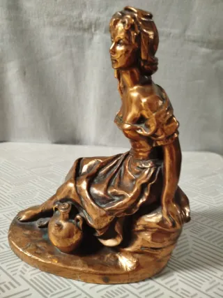 Escultura de mujer sentada con cántaro, en bronce.