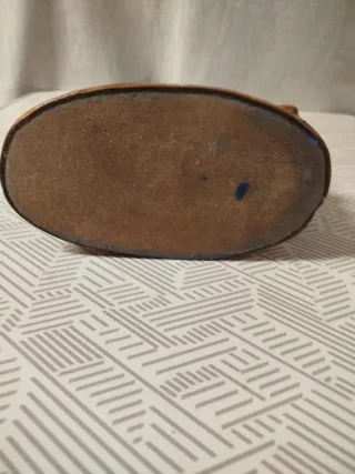 Escultura de mujer sentada con cántaro, en bronce.