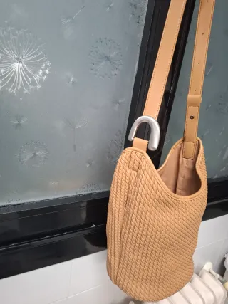 Bolso saco beige con detalle metálico