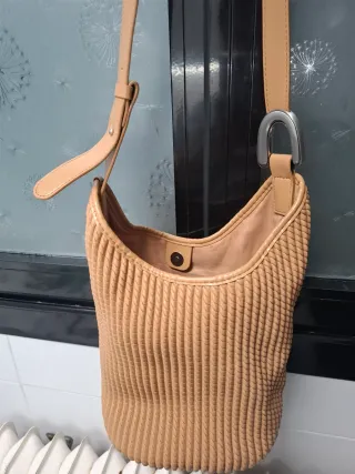 Bolso saco beige con detalle metálico
