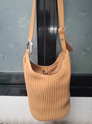 Bolso saco beige con detalle metálico