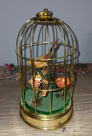 Jaula musical antigua con pájaro autómata
