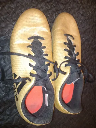 Zapatos de fútbol Adidas dorados y negros