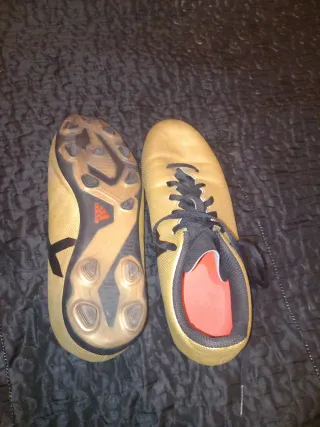 Zapatos de fútbol Adidas dorados y negros