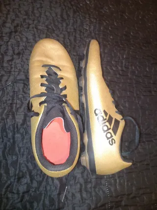 Zapatos de fútbol Adidas dorados y negros