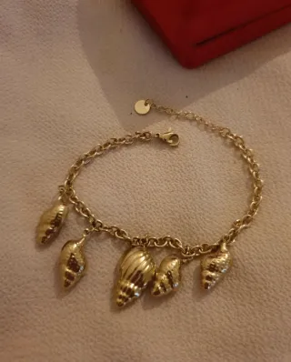 Pulsera dorada con colgantes de conchas