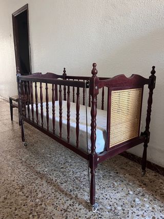 Vecchia culla in legno con materasso