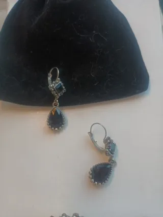 Pendientes y broche plateados con detalles negros