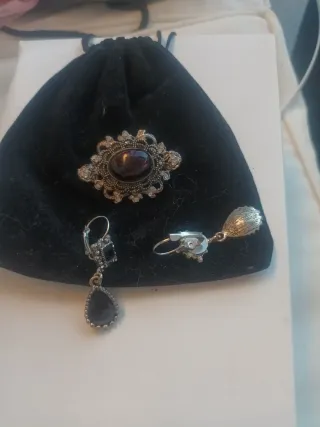 Pendientes y broche plateados con detalles negros