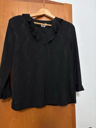 Elegante blusa negra con volantes