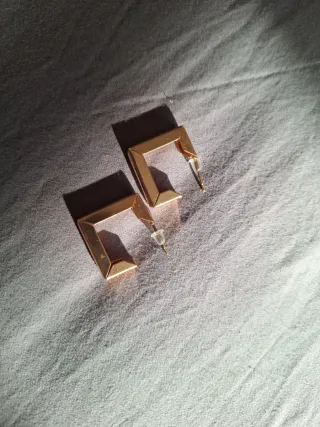 Orecchini dorati a cerchio e quadrati