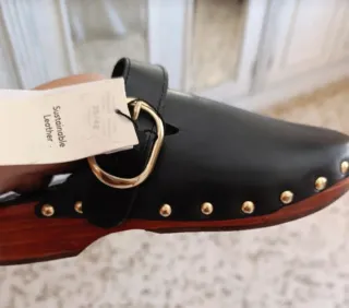 Zuecos de piel negros con hebilla dorada