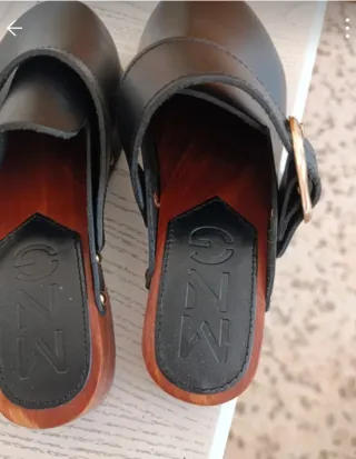 Zuecos de piel negros con hebilla dorada