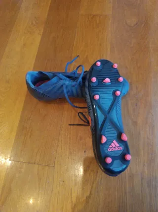 Botas de fútbol Adidas azul oscuro y rojo.