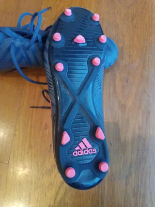Botas de fútbol Adidas azul oscuro y rojo.