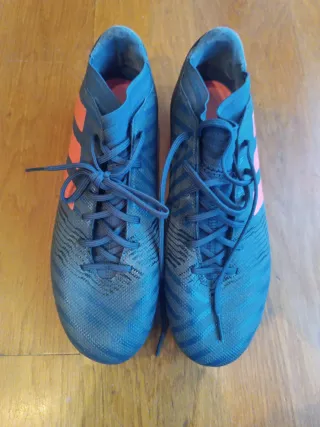 Botas de fútbol Adidas azul oscuro y rojo.