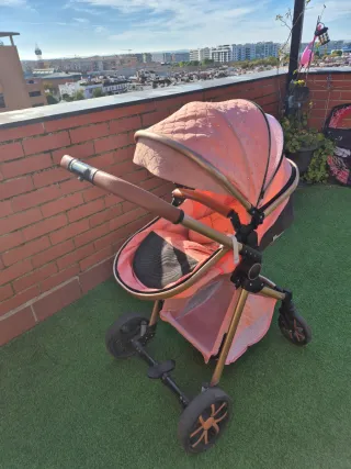 Carrito de bebé rosa con detalles brillantes