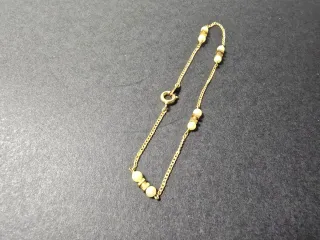 Pulsera dorada con perlas