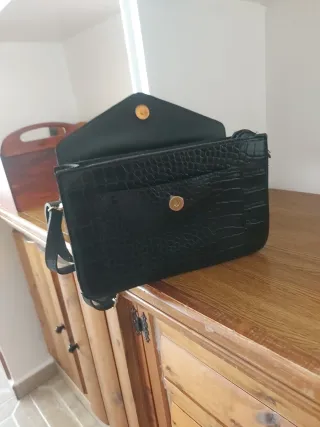 Bolso negro con detalle V y fleco