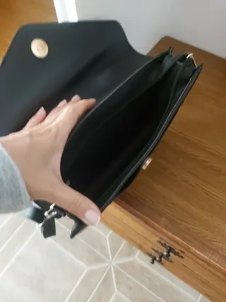 Bolso negro con detalle V y fleco