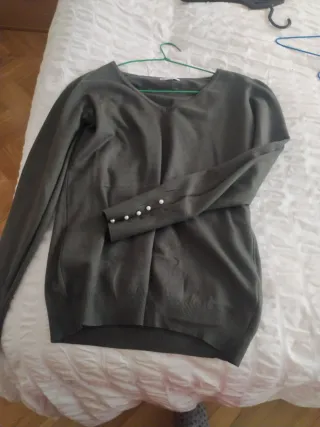 Jersey cuello pico perlas en puños.
