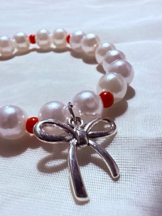 Pulsera perlas y detalles rojos con charm
