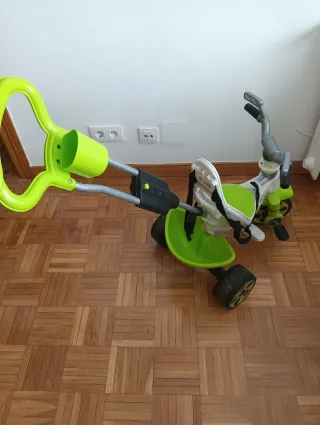 Triciclo verde con manillar de empuje