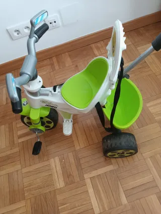 Triciclo verde con manillar de empuje