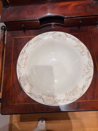 Antiguo lavamanos con espejo y pieza de cerámica.