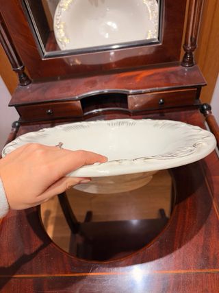 Antiguo lavamanos con espejo y pieza de cerámica.