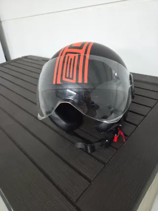 Casco de moto negro con franja naranja