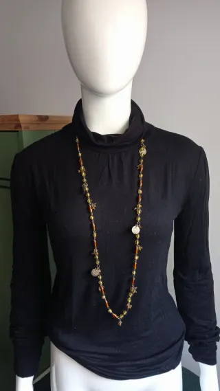 Jersey cuello alto negro con detalles dorados